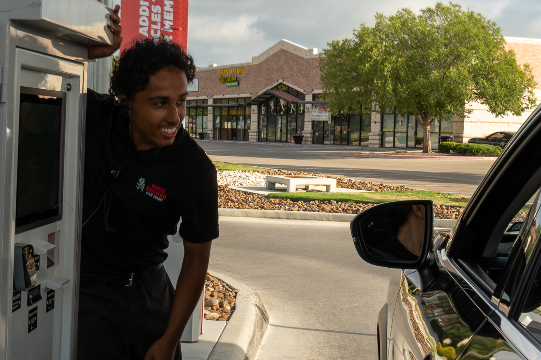 Suds Deluxe Car Wash San Marcos Wonder World Team Member Helping Customer at Pay Station