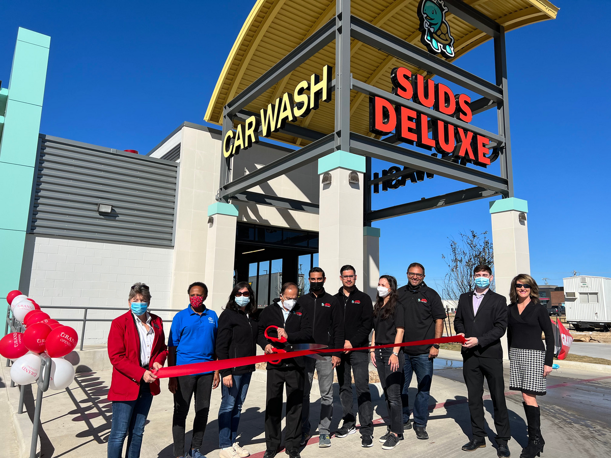 This photograph shows the Suds Deluxe team and Kyle Chamber of Commerce at the Kyle location's Ribbon Cutting Ceremony.